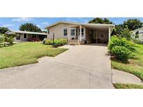 Charming single-story home with a well-maintained lawn and a convenient carport at 451 Village Sw Cir, Winter Haven, FL 33880