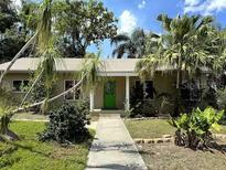 Charming single-story home with lush landscaping and a welcoming green front door at 645 Avenue A Ne, Winter Haven, FL 33881