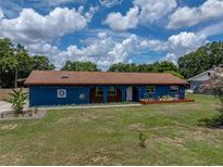 Charming blue single-story home with well-maintained lawn, brown roof, and inviting front entrance at 7150 Orange Way, Lakeland, FL 33810