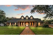 Charming brick home featuring a manicured lawn and a welcoming brick walkway leading to the front door at 1960 High Vista Dr, Lakeland, FL 33813