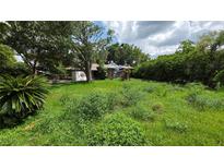 Overgrown front yard of a single-Gathering home with damaged roof and PODS storage container in the driveway at 2637 Grace Mnr, Lakeland, FL 33812
