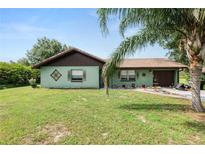 Charming single-story home with a well-maintained lawn and mature landscaping at 2700 Park Ave, Indian Lake Estates, FL 33855