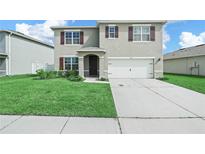 Charming two-story home featuring a well-manicured lawn and a two-car garage at 2811 Grandbury Grove, Lakeland, FL 33811