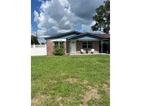 Charming single-story home with brick accents, covered carport, and well-maintained front lawn at 5907 Sharon Ln, Lakeland, FL 33809