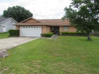 Charming single-story home with a well-manicured lawn and mature tree offering curb appeal at 7923 Glenridge E Loop, Lakeland, FL 33809