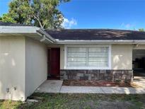 Charming home exterior with red door, stone accents and well-maintained landscaping at 105 Byron Pl, Winter Haven, FL 33884