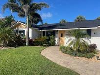 Charming single-story home featuring lush landscaping, a winding walkway, and a welcoming entrance at 4606 Doris Dr, New Smyrna Beach, FL 32169