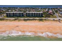 A picturesque aerial view of a condo complex situated on a beautiful beach with stunning ocean views at 3180 Ocean Shore Blvd # 208, Ormond Beach, FL 32176
