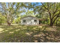 Ranch style home with covered patio, surrounded by lush trees at 4660 Holly Rd, New Smyrna Beach, FL 32168