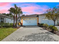 Charming home featuring a paver driveway, two-car garage, and well-maintained landscaping at 306 Coral Reef Way, Daytona Beach, FL 32124