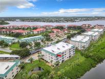 Scenic aerial view of waterfront condos with lush landscaping and serene water views on a sunny day at 426 Bouchelle Dr # 303, New Smyrna Beach, FL 32169