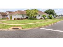Charming one-story home with lush lawn, mature landscaping, and a two-car garage at 682 Middlebury Loop, New Smyrna Beach, FL 32168