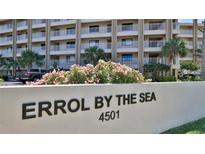Exterior shot of Errol By The Sea condominiums, boasting balconies, palm trees, and lush landscaping at 4501 S Atlantic Ave # 1150, New Smyrna Beach, FL 32169