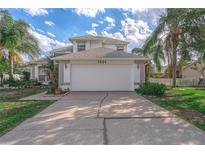 Two-story house with white garage door, landscaping, and driveway at 1381 S Wembley Cir, Port Orange, FL 32128