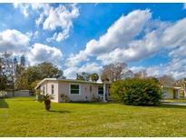 Charming ranch home with a well-manicured lawn and lush landscaping at 144 Ellison Ave, New Smyrna Beach, FL 32168