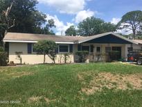 Charming single-story home with a well-maintained lawn and mature trees enhancing its curb appeal at 1500 Wildrose Ln, Daytona Beach, FL 32117
