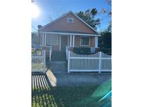 Charming bungalow with white picket fence and well-maintained lawn at 202 S Myrtle Ave, New Smyrna Beach, FL 32168