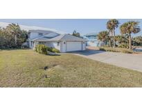 White two-story house with attached garage and grassy yard at 239 Kirkland Rd, New Smyrna Beach, FL 32169