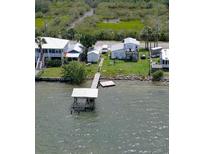 Aerial view of waterfront property with private dock and lush landscaping at 303 River Rd, Oak Hill, FL 32759