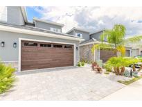 Two-car garage with wood-like panel door and paver driveway at 3066 Isles Way, New Smyrna Beach, FL 32168