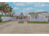 A charming two-story beach cottage with a white picket fence and a spacious yard at 321 Jessamine Ave, New Smyrna Beach, FL 32169