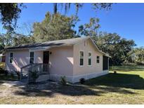 Pink house with gray porch, white trim, and a spacious yard at 388 N Glencoe Rd, New Smyrna Beach, FL 32168