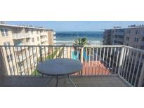 Oceanfront balcony view with patio table, pool, and partial ocean view at 4155 S Atlantic Ave # 5090, New Smyrna Beach, FL 32169