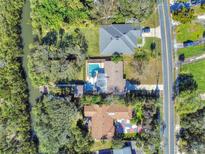 Aerial view showing a home with a pool, dock, and waterway access at 4514 Saxon Dr, New Smyrna Beach, FL 32169