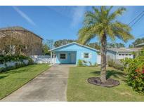 Charming light blue single story home with a mature palm tree and a well manicured lawn at 826 E 12Th Ave, New Smyrna Beach, FL 32169