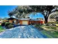 Attractive orange house with a large tree and long driveway at 1202 12Th St, Edgewater, FL 32132