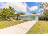 Light blue house with a driveway and grassy yard at 1210 Washington St, New Smyrna Beach, FL 32168