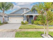 Curb appeal abounds in this charming one-story home featuring a two-car garage and lush landscaping at 3014 Borassus Dr, New Smyrna Beach, FL 32168