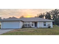 Single-story house with a white garage door and a neatly trimmed lawn at 3020 Kumquat Dr, Edgewater, FL 32141