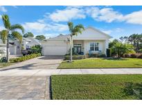 One-story home with light-colored siding, a two-car garage, and a landscaped front yard at 3037 Borassus Dr, New Smyrna Beach, FL 32168