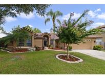 Tan house with landscaped yard, palm tree, and two-car garage at 3084 Heartleaf Pl, Winter Park, FL 32792