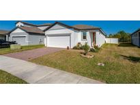 Charming single-Gathering home featuring a brick driveway, green lawn, and white exterior at 3191 Crab Trap Dr, New Smyrna Beach, FL 32168