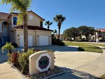 Tan two-story condo with two-car garage and landscaped grounds at 439 Bouchelle Dr # 202, New Smyrna Beach, FL 32169