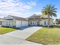 Beautiful tan house with three-car garage and palm tree at 508 Campana St, New Smyrna Beach, FL 32168