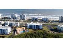 Aerial view of oceanfront community with pool and lush landscaping at 5300 S Atlantic Ave # 17-206, New Smyrna Beach, FL 32169