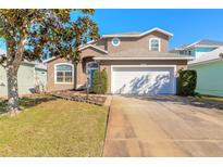 Two-story house with a white garage door and landscaping at 5727 Riverside Dr, Port Orange, FL 32127