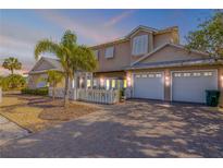 Charming two-story home featuring a three-car garage, white picket fence, and lush landscaping at 201 S Cooper St, New Smyrna Beach, FL 32169