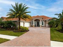 Elegant single-story home boasting a three-car garage, brick-paved driveway, and mature landscaping at 2824 S Asciano Ct, New Smyrna Beach, FL 32168