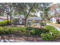 Brick house with mature landscaping, large yard, and driveway at 3120 Pine Tree Dr, Edgewater, FL 32141