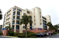 Tan building with blue accents and palm trees, offering multiple levels and parking at 5300 S Atlantic Ave # 8-302, New Smyrna Beach, FL 32169