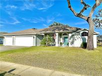 Charming single-story home features a three-car garage and a well-maintained lawn under a bright blue sky at 107 Old Sunbeam Dr, South Daytona, FL 32119