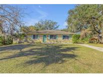 Cute ranch home with green shutters and a well-manicured lawn at 1732 Travelers Palm Dr, Edgewater, FL 32132