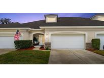 Inviting exterior of two-story townhome with attached garage and landscaped lawn at 1957 Turnbull Lakes Dr, New Smyrna Beach, FL 32168