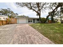 Light green house with brick driveway, and mature trees in the front yard at 2307 Saxon Dr, New Smyrna Beach, FL 32169