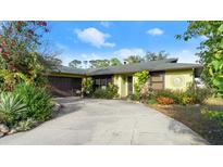 Charming single-story home featuring lush landscaping, a curved driveway and inviting curb appeal at 2813 Sabal Palm Dr, Edgewater, FL 32141