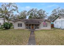 Charming single-story home featuring a welcoming front porch, tidy landscaping, and an American flag at 314 Hillman St, New Smyrna Beach, FL 32168